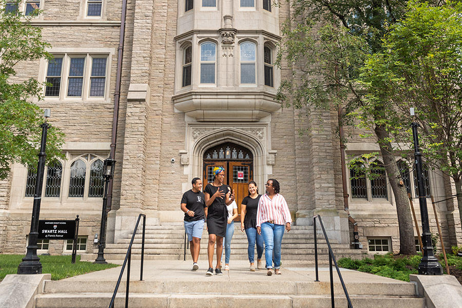 Group of HDS students walking down the path from the tower entrance to Swartz Hall