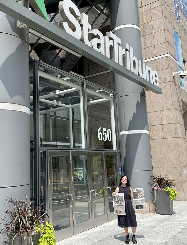Auds Jenkins, MDiv 24, stands in front of the Star Tribune’s office in downtown Minneapolis holding the print versions of the newspaper.