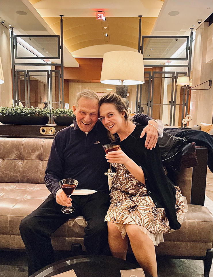 Madeline Bugeau-Heartt with her grandfather holding drinks and seated