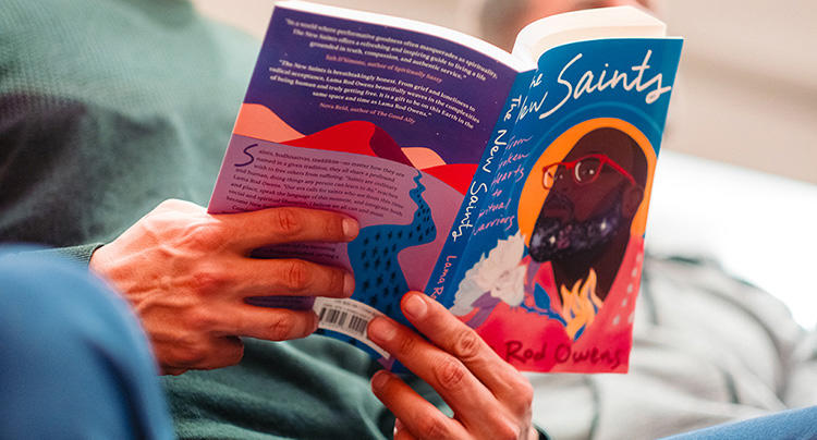 Person holding a copy of the New Saints book by Lama Rod Owens