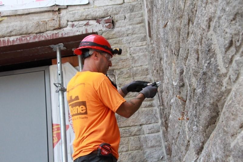 Worker at exterior wall of Swartz Hall