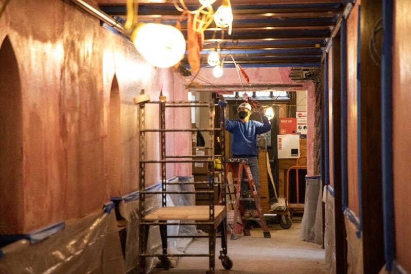 Worker in Swartz Hall hallway doing interior work