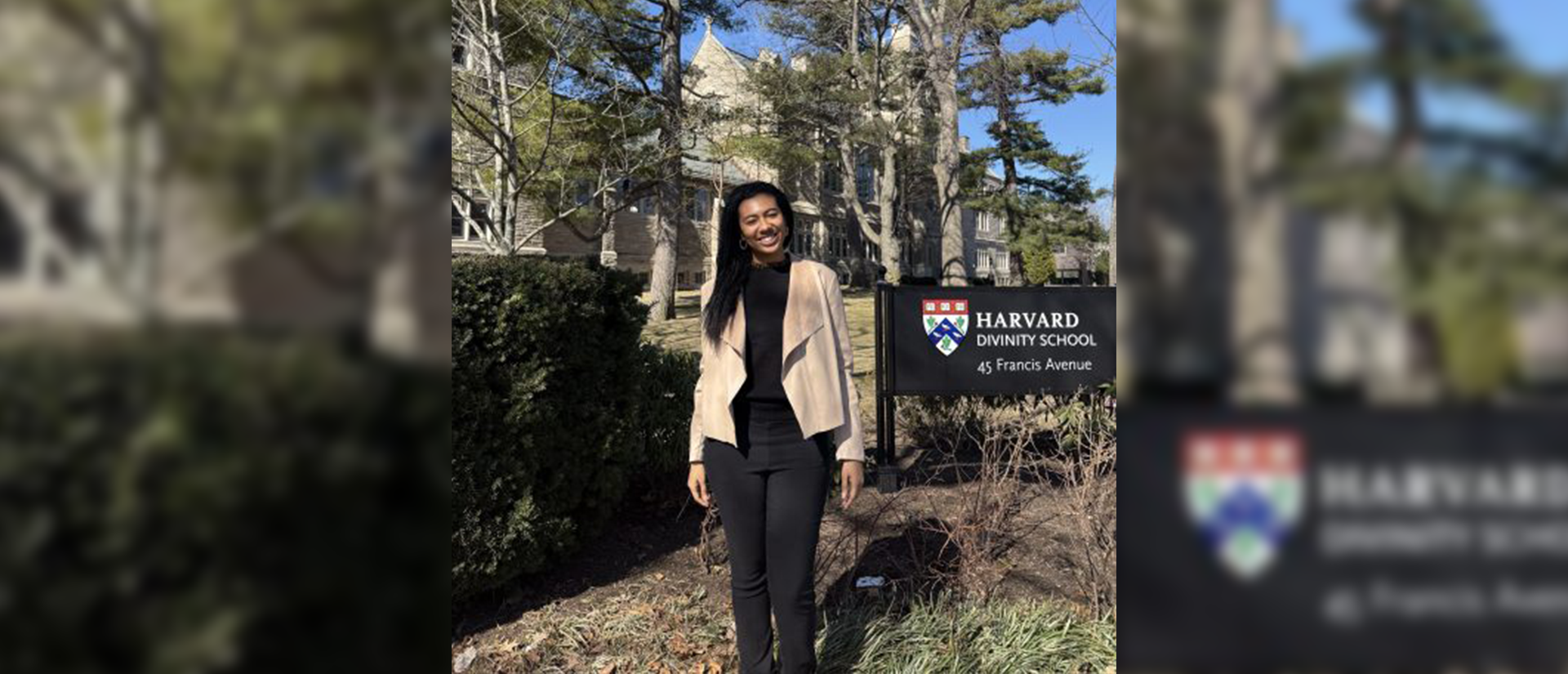 Janeen stands smiling in front of green shrubs, trees, and the back of Swartz Hall. The HDS school sign is to her left.