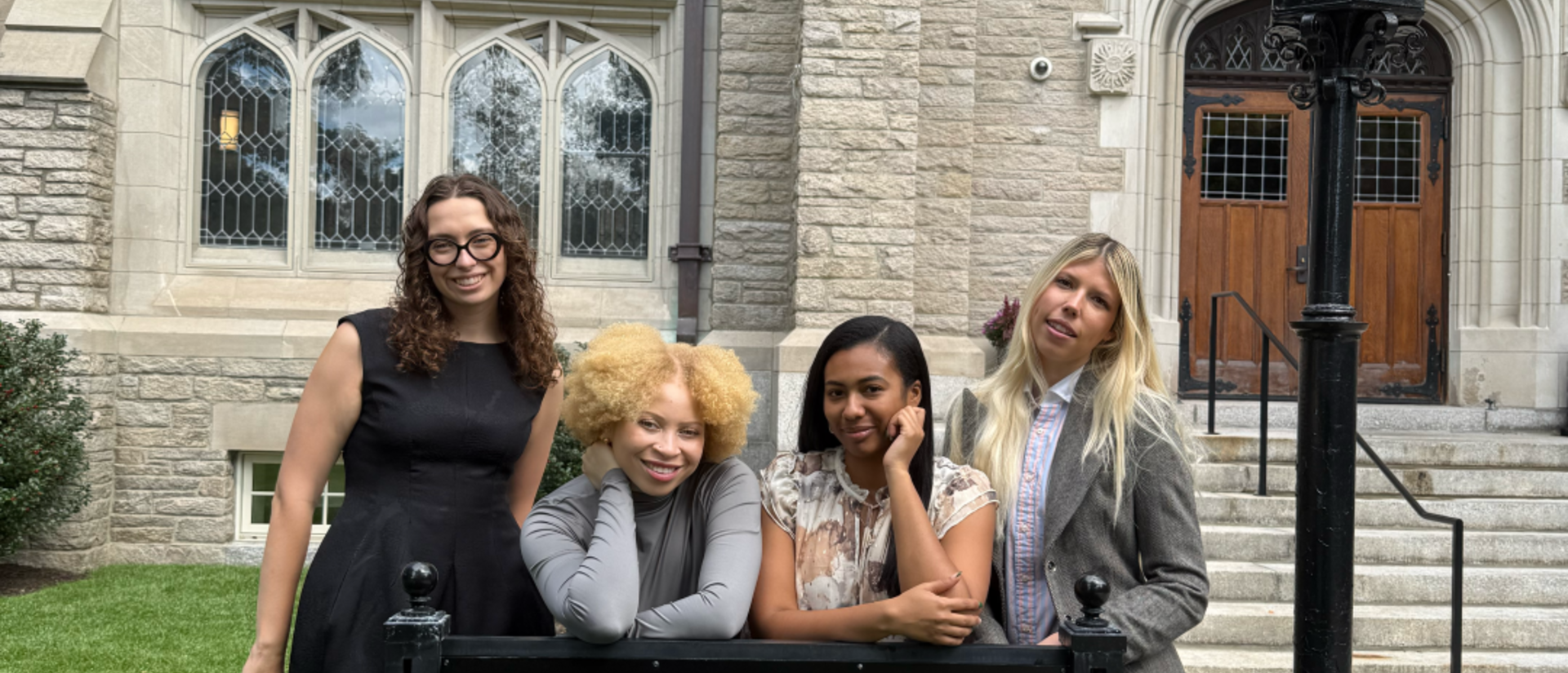 All four HDS Admissions Graduate Assistants, on the grass behind the sign for Swartz Hall on the HDS campus.