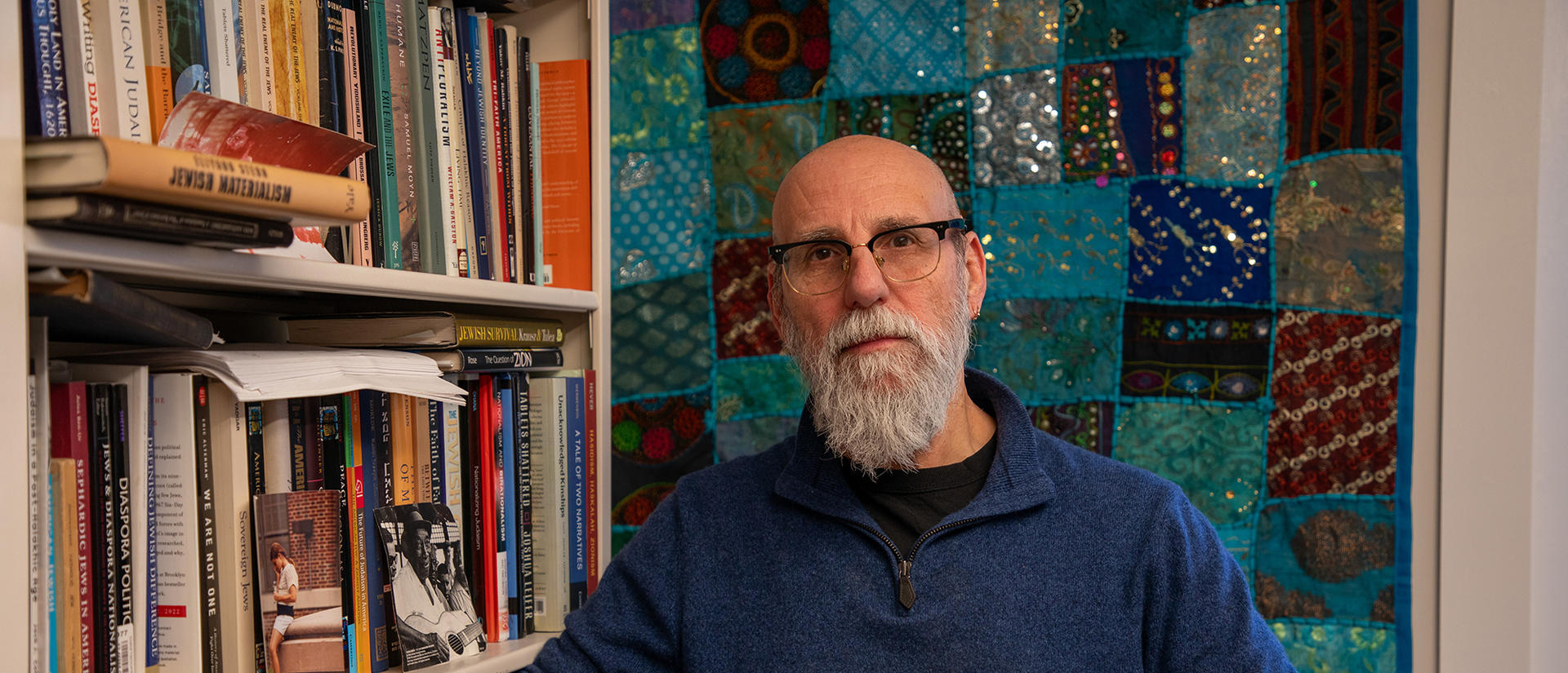 Shaul Magid standing next to bookcase