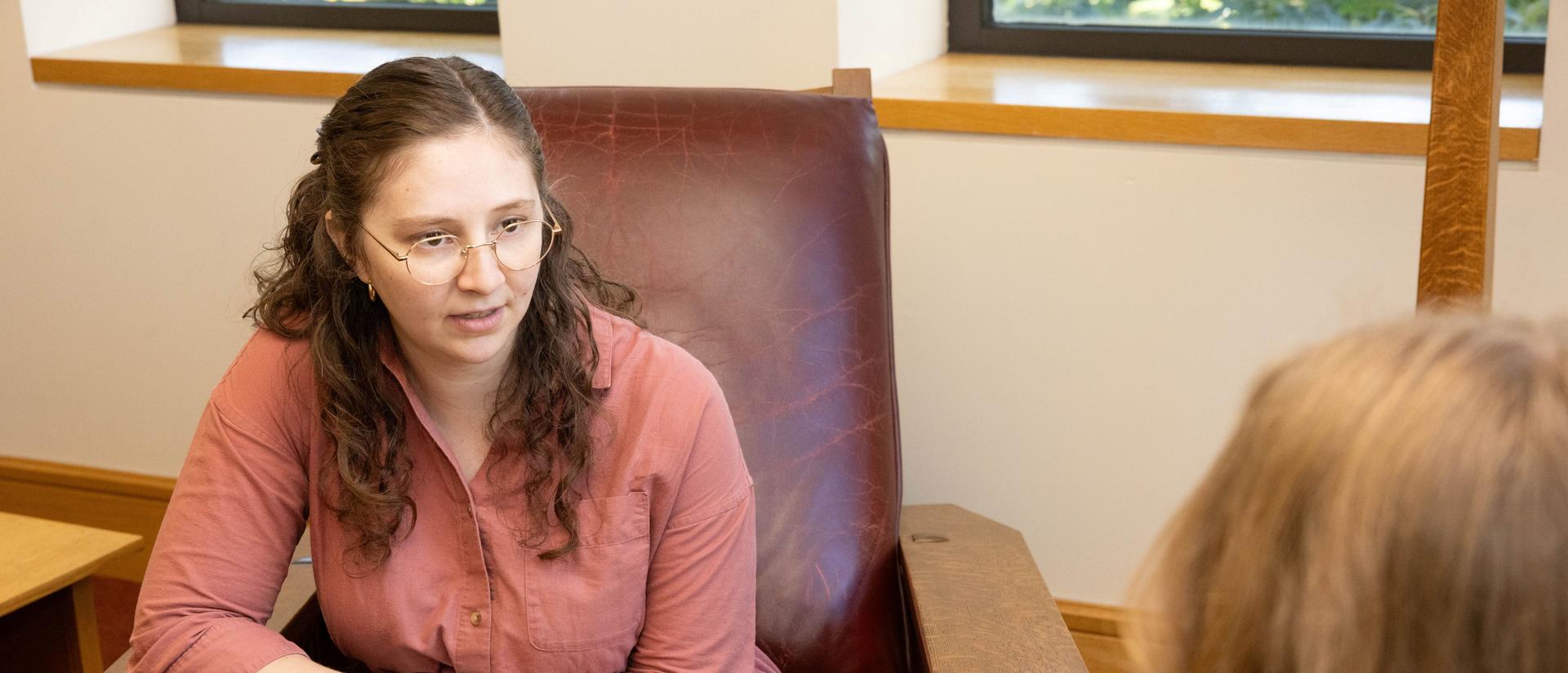 An HDS student facing the camera engages in discussion with another in the HDS Library