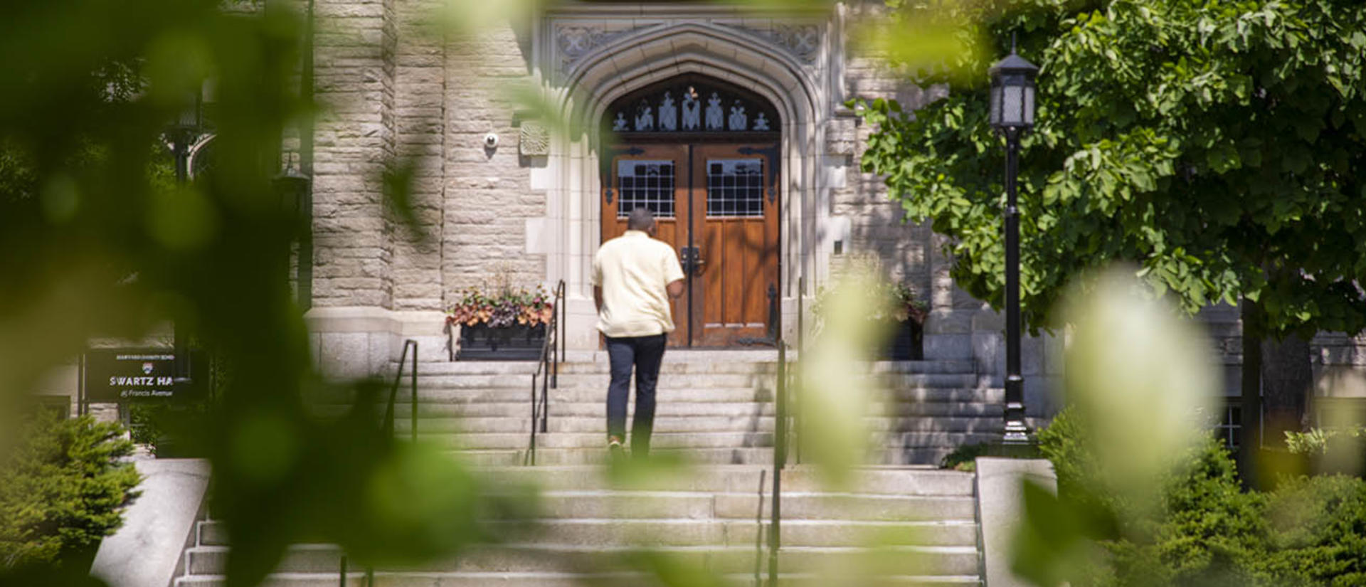 Man walking up the steps of Swartz Hall toward the entrance