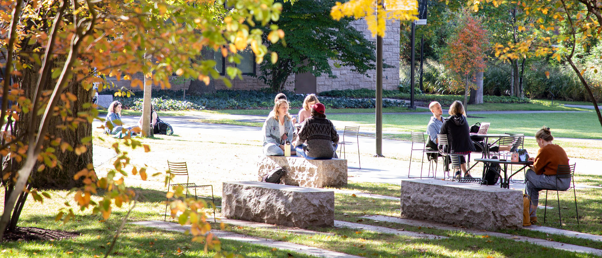 HDS students seated at tables on the campus green