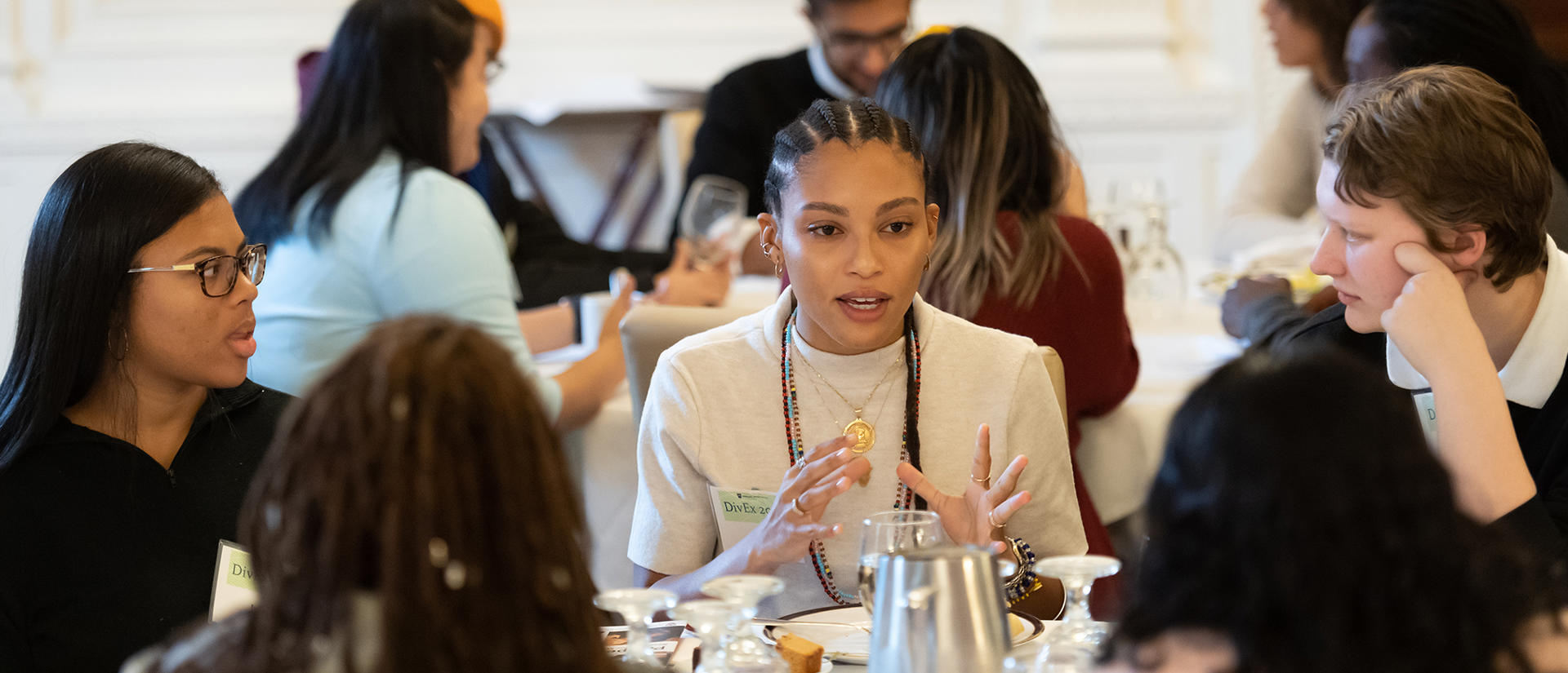 DivEx students sit around a table and discuss