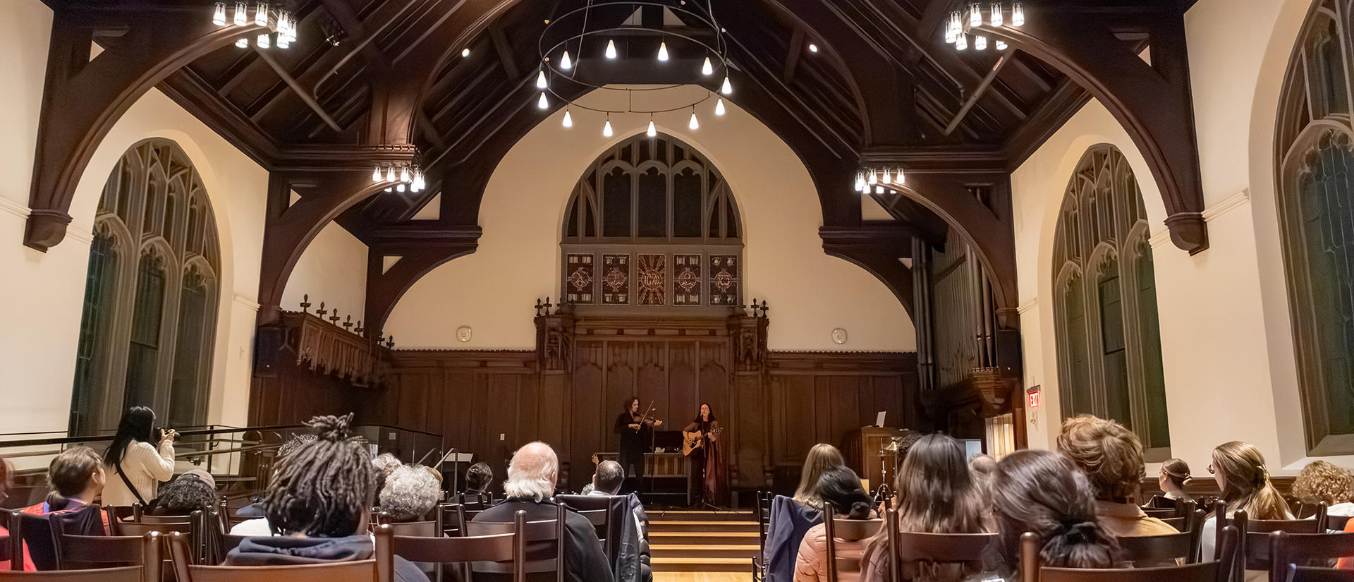 Audience members look ahead during a musical performance in Williams Chapel