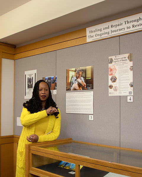 Wood-Bartholomew in front of the exhibit, talking to viewers